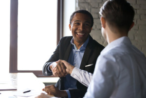 IT professional shaking hands with a business client during a technology consultation